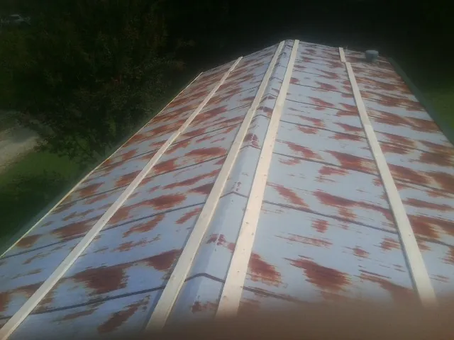 Rusted metal roof panels with new wood purlins before replacement — Storm Damage Roof Repair in Candor by Roofing Brothers