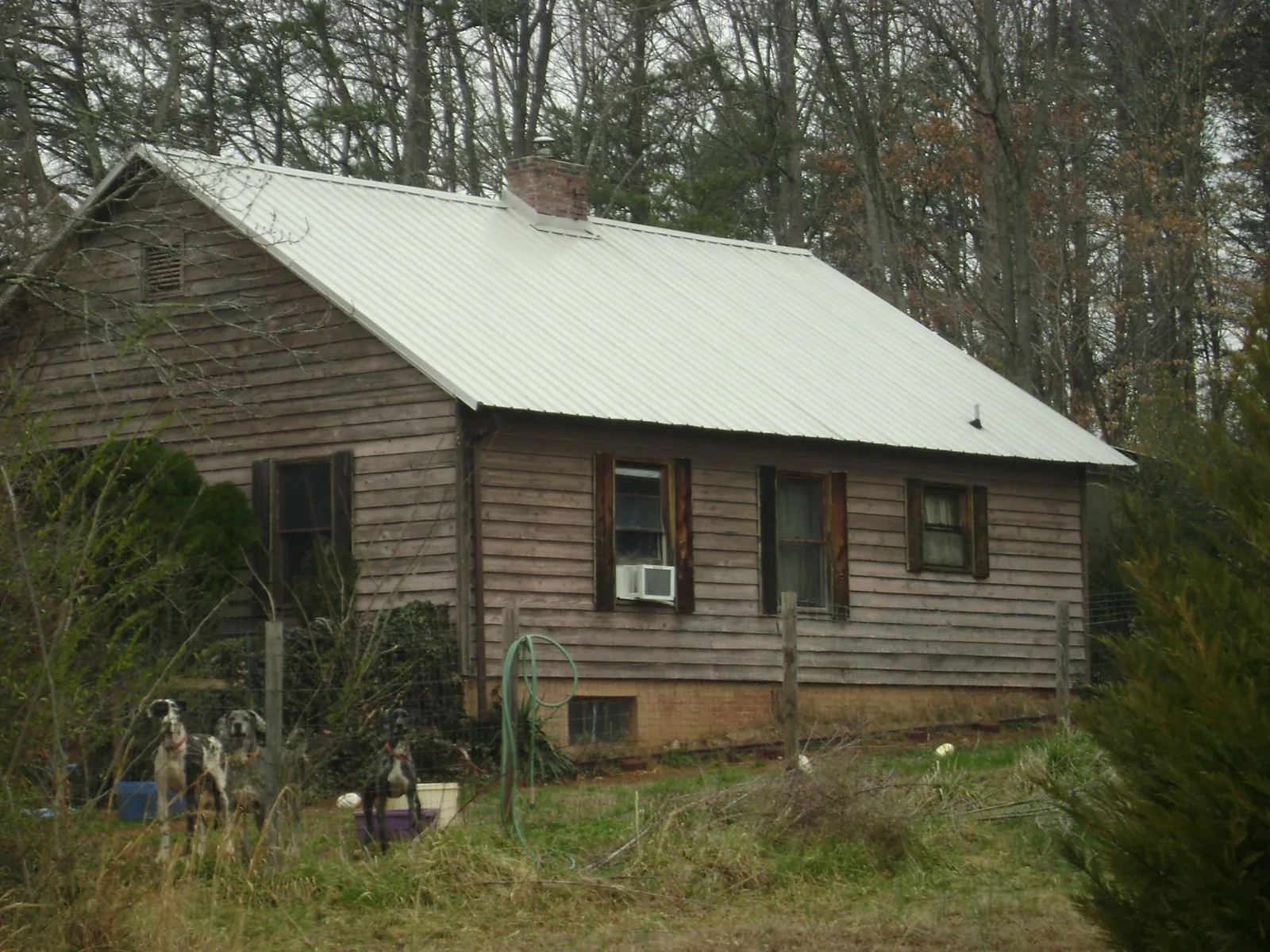 White metal roof on an old wood sided farmhouse, from a Metal Roof Installation job in Candor